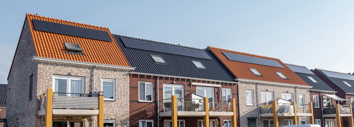 Nieuw gebouwde huizen met zonnepanelen op het dak met op de achtergrond een mooie blauwe lucht