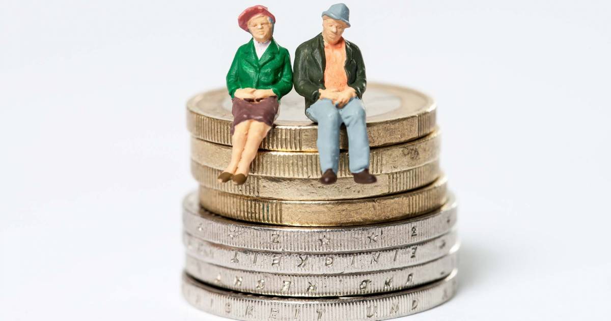 Senioren paar zittend op een stapel euromunten