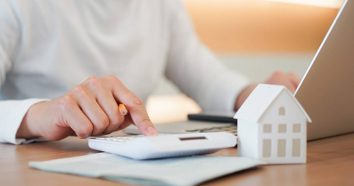 man berekent met een calculator de kosten voor zijn hypotheek